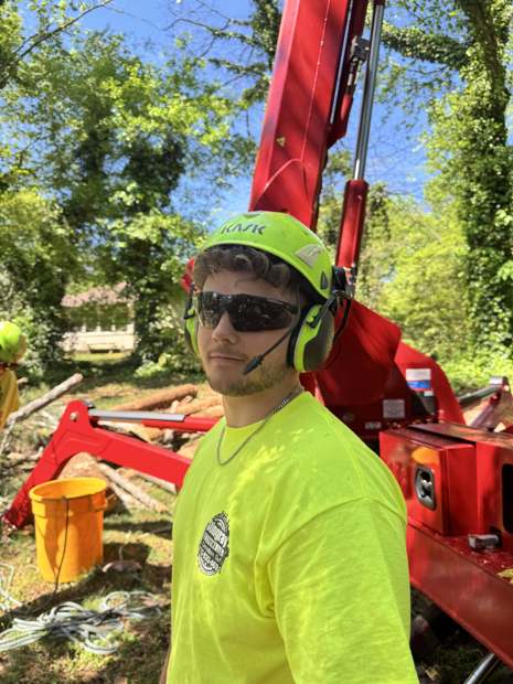 Stingray crew member in a helmet and safety shirt beside the spider lift
