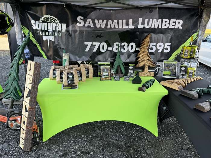 Stingray's Sawmill Lumber booth with carvings and bagged smoking chips